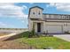 Two-story townhouse with an attached garage, a covered entry, and a well-maintained lawn at 1805 Archer Dr, Minneola, FL 34715