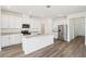 Bright kitchen features white cabinets, stainless steel appliances, and a large center island with sink at 1805 Archer Dr, Minneola, FL 34715