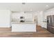 Bright, spacious kitchen features white cabinets, stainless steel appliances, and a large center island at 1805 Archer Dr, Minneola, FL 34715