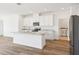 Bright, spacious kitchen features white cabinets, stainless steel appliances, and a large center island at 1805 Archer Dr, Minneola, FL 34715