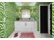 Chic bathroom featuring unique green wallpaper, white vanity with gold fixtures, and tiled flooring at 200 Carolina Ave # 201, Winter Park, FL 32789