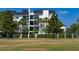 Modern white building with balconies, palm trees, and manicured hedges, offering a stylish living environment at 200 Carolina Ave # 201, Winter Park, FL 32789