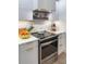 Kitchen featuring modern stainless steel oven and cooktop, white countertops, and matching white cabinetry at 200 Carolina Ave # 201, Winter Park, FL 32789