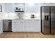Modern kitchen with white cabinets, gold hardware, stainless steel appliances, and light hardwood flooring at 200 Carolina Ave # 201, Winter Park, FL 32789