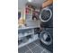 Well-organized laundry room features stacked washer/dryer, geometric floors and ample shelving for storage at 200 Carolina Ave # 201, Winter Park, FL 32789