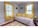Bright bedroom with sunny yellow accents, decorative pillows, and stylish sunflower artwork at 200 W 27Th St, Sanford, FL 32773