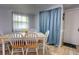Bright dining room featuring a light wood table with white chairs, and a window with floral curtains at 200 W 27Th St, Sanford, FL 32773