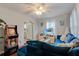 Comfortable living room featuring an arcade game, a blue sofa, and view of the kitchen at 200 W 27Th St, Sanford, FL 32773