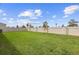 Spacious backyard featuring a well-maintained lawn and a tall white fence for privacy at 2003 Spring Shower Cir, Kissimmee, FL 34744