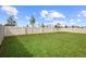 Spacious backyard featuring a well-maintained lawn and a tall white fence for privacy at 2003 Spring Shower Cir, Kissimmee, FL 34744