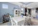 Bright dining room with white table, chairs, and decorative hutch, illuminated by an elegant chandelier at 2003 Spring Shower Cir, Kissimmee, FL 34744
