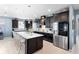 Modern kitchen with island, stainless steel appliances, and dark wood cabinets at 2003 Spring Shower Cir, Kissimmee, FL 34744
