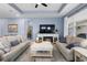 Cozy living room featuring two sofas, ceiling fan, fireplace, and tray ceiling at 2003 Spring Shower Cir, Kissimmee, FL 34744