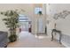 Inviting foyer with a tall ceiling, plant, and view into a bedroom with natural light streaming through the window at 2655 Star Lake View Dr, Kissimmee, FL 34747