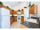 Well-lit kitchen featuring wood cabinetry, granite countertops, and modern white appliances at 2655 Star Lake View Dr, Kissimmee, FL 34747