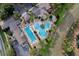 Overhead view of a large community pool area with palm trees, cabanas, lounge chairs, and lush landscaping at 26807 Bull Run, Leesburg, FL 34748