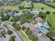 Aerial view of a community clubhouse, pool, parking area, and golf course at 26807 Bull Run, Leesburg, FL 34748
