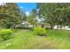 Beautifully landscaped backyard with lush lawn, mature trees, and manicured shrubs at 26807 Bull Run, Leesburg, FL 34748