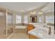 Bathroom showcasing a soaking tub, glass-enclosed shower, and dual sink vanity with a large mirror at 26807 Bull Run, Leesburg, FL 34748