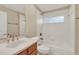 Well-lit bathroom featuring a tiled shower-tub combination and a wood vanity with a sink at 26807 Bull Run, Leesburg, FL 34748