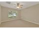 Carpeted bedroom showcasing a large window and ceiling fan for a bright and airy feel at 26807 Bull Run, Leesburg, FL 34748