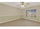 Bright carpeted bedroom featuring neutral walls, a ceiling fan, and a large window at 26807 Bull Run, Leesburg, FL 34748
