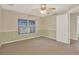 Neutral bedroom featuring a ceiling fan, window, and paneled walls in a cozy and inviting space at 26807 Bull Run, Leesburg, FL 34748