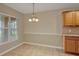 Dining room features tiled floors, neutral walls, chandelier and bright window with wooded view at 26807 Bull Run, Leesburg, FL 34748
