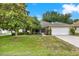 Charming single-story home with a well-manicured lawn and a two car garage, under a clear blue sky at 26807 Bull Run, Leesburg, FL 34748