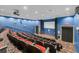 This home theater features tiered seating, a projector, a large screen, and exit doors for the ultimate viewing experience at 26807 Bull Run, Leesburg, FL 34748