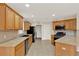 Kitchen featuring ample wood cabinets, black appliances and tile backsplash, offers great utility at 26807 Bull Run, Leesburg, FL 34748