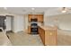 Kitchen area with wood cabinets, breakfast bar, and black gas range and microwave, ready for cooking at 26807 Bull Run, Leesburg, FL 34748