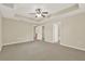 Main bedroom featuring neutral carpet, ceiling fan, and access to an ensuite bathroom and walk-in closet at 26807 Bull Run, Leesburg, FL 34748