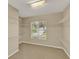 Large walk-in closet with carpet floors, white wire shelving, and a window for natural light at 26807 Bull Run, Leesburg, FL 34748