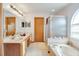 Elegant bathroom featuring a double vanity, shower, and soaking tub with natural light at 2712 Rolling Broak Dr, Orlando, FL 32837