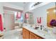 Well-lit bathroom with double sinks, marble countertops, and a shower-tub combination at 2712 Rolling Broak Dr, Orlando, FL 32837