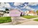Charming pink two-story home with a well-manicured lawn and a two-car garage at 2712 Rolling Broak Dr, Orlando, FL 32837