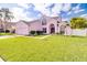 Charming pink two-story home with a well-manicured lawn and a two-car garage at 2712 Rolling Broak Dr, Orlando, FL 32837