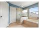 This bathroom features a glass shower, soaking tub, and linen closet at 3468 Woodley Park Pl, Oviedo, FL 32765
