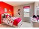 bedroom with red accent wall, Disney-themed decor, and a large window with polka-dot curtains at 3617 Fort Mellon Ln, Sanford, FL 32773
