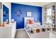 Bright bedroom with a blue wall, sports-themed decor, and a large window with curtains at 3617 Fort Mellon Ln, Sanford, FL 32773