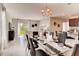 Open-concept dining area with a glass table, modern chairs, and view to the living room at 3617 Fort Mellon Ln, Sanford, FL 32773