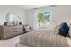 Bright bedroom featuring a comfortable bed, a dresser with a mirror, and natural light at 3641 Fort Mellon Ln, Sanford, FL 32773