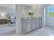 Bathroom featuring dual sinks with granite counters, white cabinets, and a mirror, alongside a view of the bedroom at 3846 Royal Azalea Way, Sanford, FL 32773