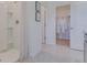 Bright bathroom with a walk-in shower, and a glimpse into a walk-in closet with organized storage solutions at 3846 Royal Azalea Way, Sanford, FL 32773