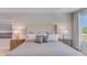 Comfortable bedroom featuring a tufted headboard, soft neutral tones, and abundant natural light from a large window at 3846 Royal Azalea Way, Sanford, FL 32773