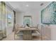 Elegant dining room with a modern table, plush seating, and large windows for natural light at 3846 Royal Azalea Way, Sanford, FL 32773