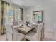 Well-lit dining room features a formal table setting with chairs, a mirror, and scenic window views at 3846 Royal Azalea Way, Sanford, FL 32773