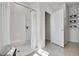 Clean bathroom featuring a white tiled shower with glass door and open shelves at 3850 Royal Azalea Way, Sanford, FL 32773