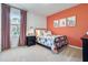 Bright bedroom with orange accent wall, natural light, and stylish decor at 3850 Royal Azalea Way, Sanford, FL 32773